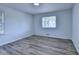 This light-filled bedroom offers wood-look floors, a window with decorative muntins and neutral walls at 4756 Fellsridge Dr, Stone Mountain, GA 30083