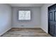 A well lit bedroom features wood look floors, window with decorative muntins and a black paneled door at 4756 Fellsridge Dr, Stone Mountain, GA 30083