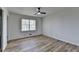 A light and airy bedroom offers wood-look floors, a modern ceiling fan and a large window at 4756 Fellsridge Dr, Stone Mountain, GA 30083