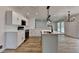 Bright kitchen features a central island, stainless steel appliances, wood flooring, and modern light fixtures at 4756 Fellsridge Dr, Stone Mountain, GA 30083