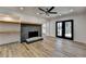 Open-concept living room with stone fireplace, hardwood floors, built in shelves, and access to outdoor patio at 4756 Fellsridge Dr, Stone Mountain, GA 30083