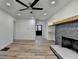 Bright living room with modern ceiling fan, stone fireplace, floating shelves and hard surface floors at 4756 Fellsridge Dr, Stone Mountain, GA 30083