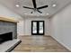 Open-concept living room featuring stone fireplace, hardwood floors, ceiling fan, and access to outdoor patio at 4756 Fellsridge Dr, Stone Mountain, GA 30083