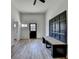 Sunlit living area with wood-look floors, bench seating and black framed front door with windows at 4756 Fellsridge Dr, Stone Mountain, GA 30083