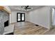 Open-concept living room with stone fireplace, hardwood floors, ceiling fan, and access to outdoor patio at 4756 Fellsridge Dr, Stone Mountain, GA 30083