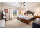 Spacious bedroom featuring a decorative wooden bed frame, plush carpeting, and a bright window at 100 Marietta Walk Trce, Marietta, GA 30064