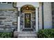 Inviting front door with stone accents, a wreath, and decorative plants at 100 Marietta Walk Trce, Marietta, GA 30064