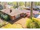 Aerial view of a brick home with a carport, surrounded by lush greenery and mature trees at 1181 Angelia Sw Dr, Mableton, GA 30126