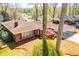 Brick home featuring a carport, landscaped yard, and surrounded by mature trees in a residential neighborhood at 1181 Angelia Sw Dr, Mableton, GA 30126