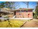 Brick home featuring covered patio, wooden railing, mature trees, and a fenced yard at 1181 Angelia Sw Dr, Mableton, GA 30126