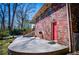 Brick home with a red door, spacious patio, and a covered carport, set in a wooded landscape at 1181 Angelia Sw Dr, Mableton, GA 30126