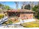 Brick home featuring a covered patio, wooden railing, mature trees, and a fenced yard at 1181 Angelia Sw Dr, Mableton, GA 30126