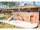 Brick home featuring a covered patio, a large concrete patio, mature trees, and a side yard at 1181 Angelia Sw Dr, Mableton, GA 30126