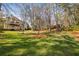 Expansive backyard featuring green grass, trees, and the back of the house with an elevated deck at 1562 Asheforde Dr, Marietta, GA 30068