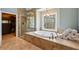 Spa-like bathroom with a soaking tub, glass shower, and large window with outdoor views at 1562 Asheforde Dr, Marietta, GA 30068