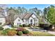 Beautiful two-story home with a well-manicured lawn, mature trees, and circular driveway at 1562 Asheforde Dr, Marietta, GA 30068