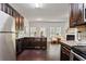 Open kitchen with stainless steel appliances, dark cabinets, recessed lights, and access to the living room at 2359 Castle Keep Way, Atlanta, GA 30316