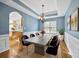 Formal dining room with blue walls, hardwood floors, and elegant chandelier at 3940 Medlock Park Dr, Snellville, GA 30039