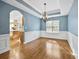 Dining room with blue walls, hardwood floors, and archway into kitchen at 3940 Medlock Park Dr, Snellville, GA 30039