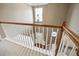 View of foyer from upstairs landing with light fixture and white rails at 3940 Medlock Park Dr, Snellville, GA 30039