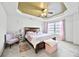 Bedroom featuring a tray ceiling, plush carpet, large window, and designer accents at 3940 Medlock Park Dr, Snellville, GA 30039