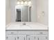 Bright bathroom with white cabinetry, quartz countertops, modern fixtures, and a large mirror at 5307 Mountain Village Ct, Stone Mountain, GA 30083