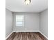 The bedroom offers wood flooring, neutral paint, and a large window for natural light at 5307 Mountain Village Ct, Stone Mountain, GA 30083
