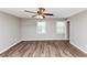 Spacious bedroom featuring wood-look floors, neutral paint, and a modern ceiling fan with lighting at 5307 Mountain Village Ct, Stone Mountain, GA 30083