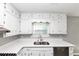 Bright kitchen boasting white countertops, a stainless steel sink, and lots of white cabinets at 5307 Mountain Village Ct, Stone Mountain, GA 30083