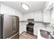 The kitchen features stainless steel appliances, including a gas range and white cabinets at 5307 Mountain Village Ct, Stone Mountain, GA 30083