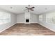 Bright living room with new floors, a fireplace, a ceiling fan, and plenty of natural light at 5307 Mountain Village Ct, Stone Mountain, GA 30083