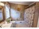 Full bathroom with textured walls, decorative mirror, and floral shower curtain at 5347 Harbury Cv, Suwanee, GA 30024