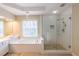 Bathroom features a soaking tub with tile surround and a glass-enclosed shower at 5347 Harbury Cv, Suwanee, GA 30024