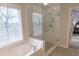This bathroom features a soaking tub with tile surround and a glass-enclosed shower at 5347 Harbury Cv, Suwanee, GA 30024