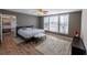 Bedroom with a ceiling fan, wood floors, large windows and modern furniture at 5347 Harbury Cv, Suwanee, GA 30024