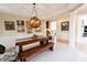 Elegant dining room with a unique light fixture, wainscoting, and marble floors at 5347 Harbury Cv, Suwanee, GA 30024