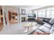 Cozy living room with fireplace, large windows, and comfortable seating, seamlessly flows into the kitchen at 5347 Harbury Cv, Suwanee, GA 30024