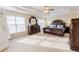 Spacious main bedroom with coffered ceiling, large windows, and luxurious, dark-wood furniture at 5347 Harbury Cv, Suwanee, GA 30024