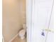 Powder room features a white toilet with a gold graphic printed on the wall above at 5347 Harbury Cv, Suwanee, GA 30024