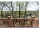 Elevated view of the surrounding lush landscape from a grey deck with a beige railing at 5347 Harbury Cv, Suwanee, GA 30024