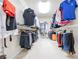 This walk-in closet features hanging clothes on rods and shelving units for accessories at 5347 Harbury Cv, Suwanee, GA 30024