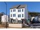 Charming two-story townhome featuring white siding, a brick base, and a beautifully landscaped front yard at 335 Skylar Se Way, Atlanta, GA 30315