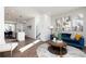 Bright living room featuring a blue sofa, stylish decor, and an open floor plan leading to the kitchen at 335 Skylar Se Way, Atlanta, GA 30315