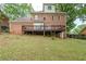 View of the backyard with a large wooden deck and brick exterior of the home at 5611 Manassas Run, Stone Mountain, GA 30087