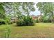 A large private backyard with a lush green lawn and mature trees at 5611 Manassas Run, Stone Mountain, GA 30087