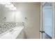 Well-lit bathroom featuring a sink with tiled backsplash and door to adjoining room at 5611 Manassas Run, Stone Mountain, GA 30087
