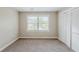 A cozy bedroom features neutral walls, plush carpet, a double window and a closet at 5611 Manassas Run, Stone Mountain, GA 30087