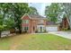 Charming two-story brick home with mature trees and a well-manicured lawn on a cloudy day at 5611 Manassas Run, Stone Mountain, GA 30087