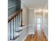 Bright hallway with hardwood floors, neutral paint, and stairway with modern white spindles at 5611 Manassas Run, Stone Mountain, GA 30087
