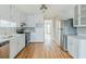 Bright kitchen with white cabinets, stainless steel appliances, and hardwood flooring at 5611 Manassas Run, Stone Mountain, GA 30087